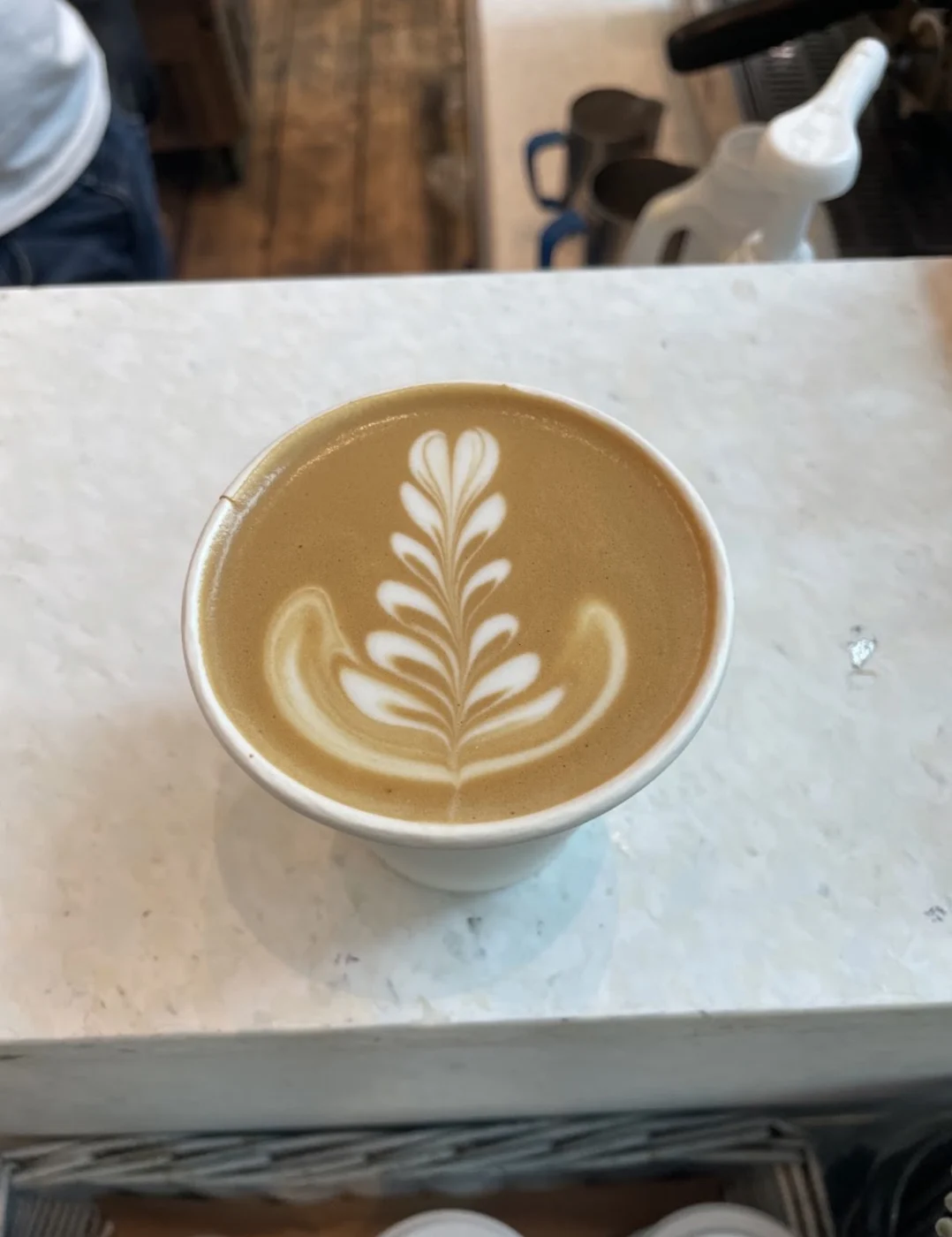 Layered rosetta latte art in a white cup
